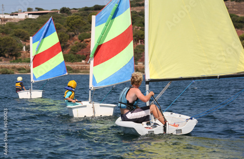 Photo: Children sailing small boats with their instructor following Children sailing small boats with their instructor following