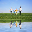 family of four running grass sky water