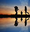 silhouette family of four and water