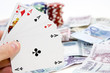 Poker hands - cards have focus with poker chips and money