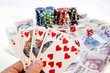 Poker hands - cards have focus with poker chips and money
