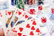 Poker hands - cards have focus with poker chips and money