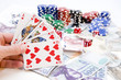 Poker hands - cards have focus with poker chips and money