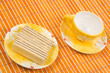 Waffle slice and empty cup on bamboo table-cloth