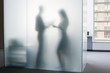 Two people behind frosted glass