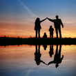 silhouette family house on sunset water