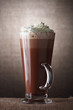 Hot Chocolate with cream in Tall Glass on brown rustic backgroun