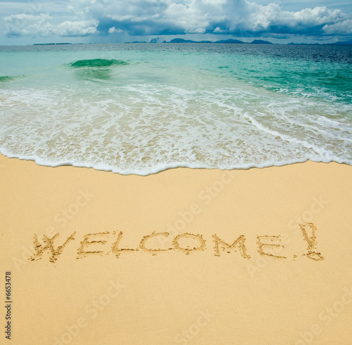 welcome written in a sandy tropical beach