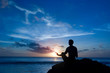 Photo: Keeping sun - young man meditating on the beach Keeping sun - young man meditating on the beach