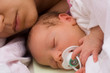 caucasian mother sleeping with her baby