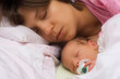 caucasian mother sleeping with her baby
