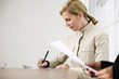 A business woman writing in an office.