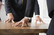 Midsection of people standing around a table.