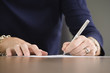 Midsection of a woman writing.