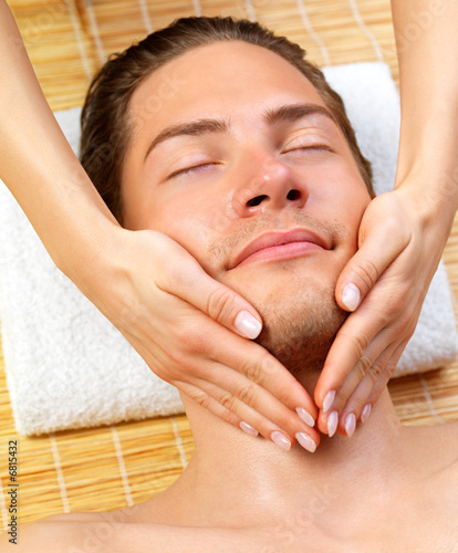 Portrait of happy man and hands giving face massage