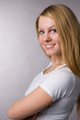 A smiling blonde on a grey background in studio. A smiling blonde on a grey background in studio.