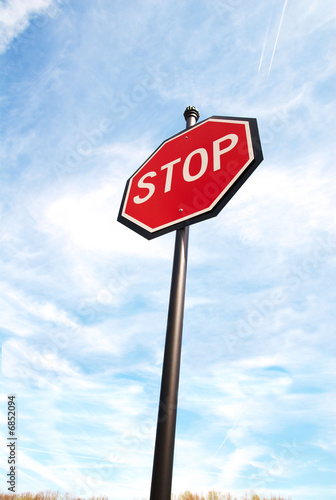 Photo: Stop sign on a blue sky from below. Stop sign on a blue sky from below.