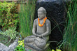 boudha en pierre avec collier