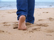 womans feet walking on the beach