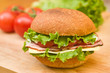 Ham & Swiss sandwich with fresh vegetables in background Ham & Swiss sandwich with fresh vegetables in background