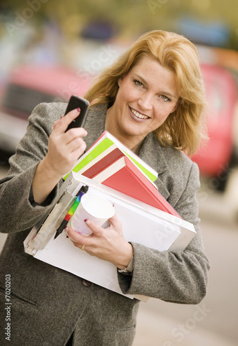 Photo: Woman with many books on a sidewalk Woman with many books on a sidewalk