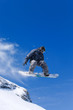 Male snowboarder jumping of a hill