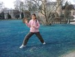 Photo: Mädchen übt Tai Chi im Park auf blauer Wiese Mädchen übt Tai Chi im Park auf blauer Wiese