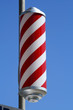 Photo: striped barbers pole set against bright blue sky striped barbers pole set against bright blue sky