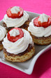 Cookies with jam, white cream and cut fresh strawberries
