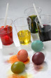 Four coloured Easter eggs and four glasses filled with colour