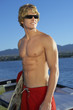 Young man holding wakeboard on boat