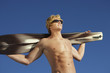 Young man holding wakeboard outdoors, low angle view