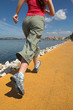 Young woman running by seaside