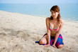 woman in bikini kneelingon the beach