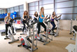 Women working out on spinning bikes at the gym