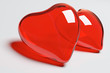two red glass hearts on the white