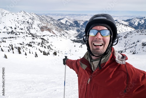 Close-up portrait of a smiling skier stretching his arms