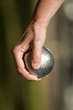 boule de pétanque dans une main