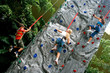 Young children doing rock climbing in an indoor sports center.