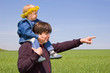 father point the way to his little son against spring meadow