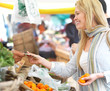 Happy blond woman buying food at market.