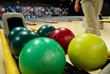 Bowling balls in the rack at a bowling alley.