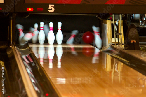 Photo: Bowling pins being knocked down. Bowling pins being knocked down.