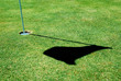A golf hole on a green of a golfcourse with focus on the flag.