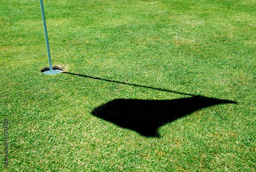 Photo: A golf hole on a green of a golfcourse with focus on the flag. A golf hole on a green of a golfcourse with focus on the flag.
