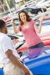 Woman picking up keys to new car.