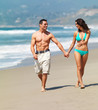 Smiling young couple walking on beach