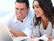 Young smiling couple looking at laptop