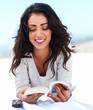 Beautiful young woman reading book on beach
