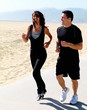 Happy young couple jogging on beach